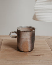 Load image into Gallery viewer, Wood fired ceramic mug on a wooden surface with a neutral background
