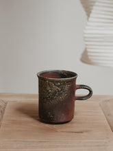 Load image into Gallery viewer, Reddish brown wood fired ceramic mug on a wooden table
