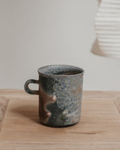 Load image into Gallery viewer, wood fired ceramic mug on a wooden surface with a neutral background
